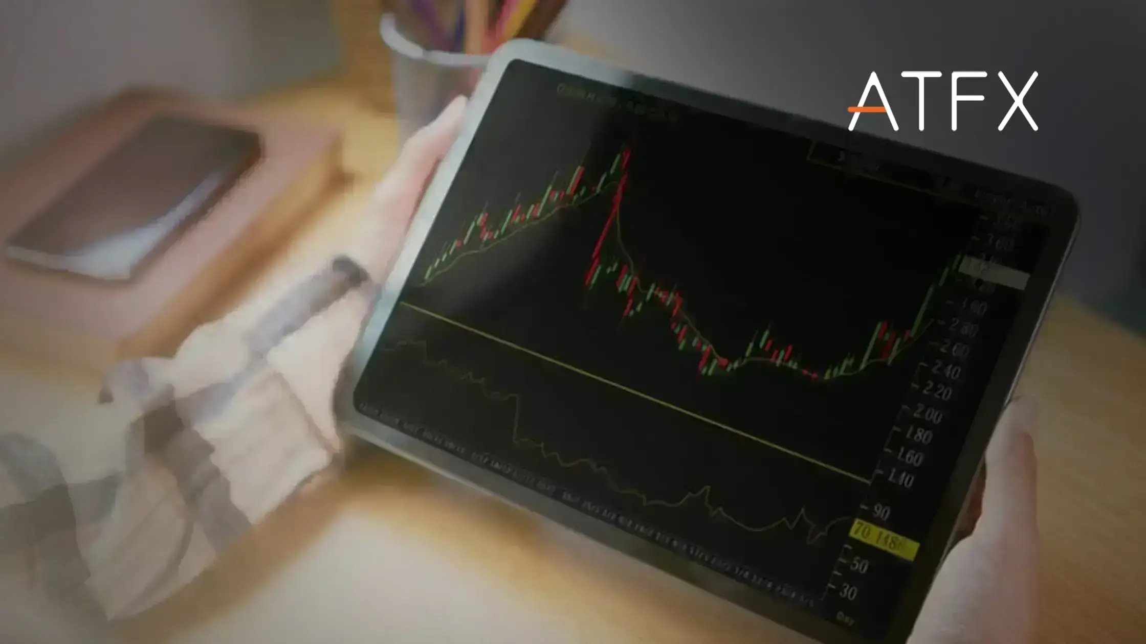 holding tablets reading candlestick charts